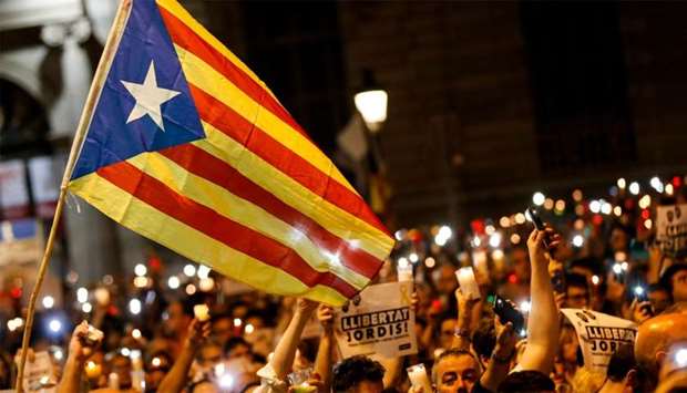people holding candles and a Catalan pro-independence 'Estelada' flag