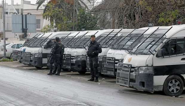 Riot policemen stand guard, in Tebourba, Tunisia