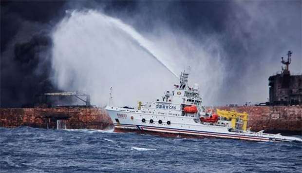Chinese firefighting vessel ,Donghaijiu 117, spraying foam on the burning oil tanker ,Sanchi, at sea off the coast of eastern China.