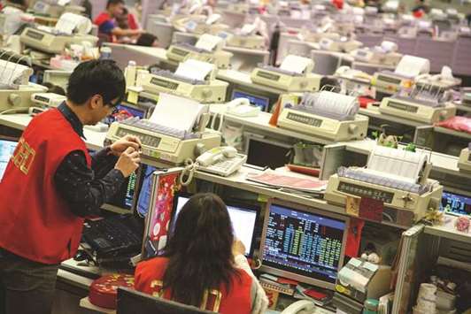 Traders at the Hong Kong Stock Exchange. The Hang Seng index surged 0.9 % to 31,412.54 points yesterday.
