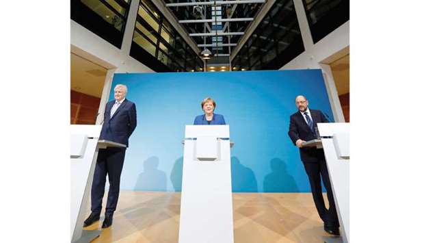 Acting German Chancellor Angela Merkel, leader of the Christian Social Union in Bavaria (CSU) Horst Seehofer and Social Democratic Party (SPD) leader Martin Schulz speak after exploratory talks about forming a new coalition government at the SPD headquarters in Berlin, Germany, yesterday.