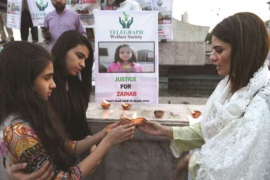 Civil society activists light oil lamps during a vigil held in tribute to a child who was abused and murdered in Karachi on January 12, yesterday.