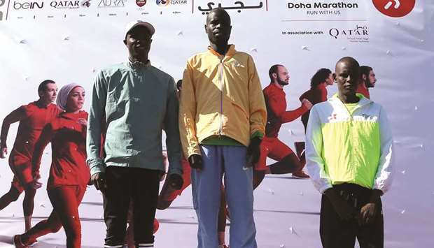 Menu2019s full marathon (42km) winner Kenyau2019s Chebii Collins Kiptarus (centre) poses with his countrymen second-placed Henry Kipsang (left) and third-placed Dickson Terer.