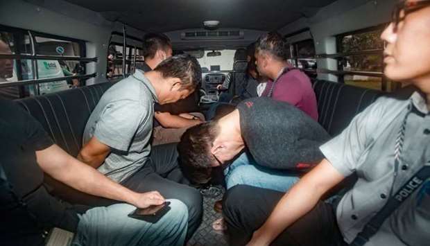 Suspects, part of a group of 17 detained over their part in an alleged oil theft at Shell's Pulau Bukom refinery, arrive in a van at the State Courts, Singapore.