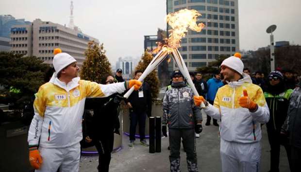 Torchbearers carry Olympic torches in Seoul, South Korea