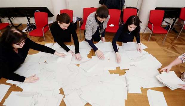 Election committee members are seen as they count votes after polling stations closed for the country's direct presidential election in Prague