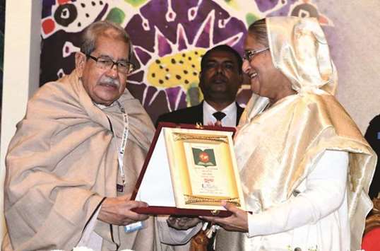 Dhaka University professor emeritus Dr Anisuzzaman presenting a commemorative present to Prime Minister Sheikh Hasina in Dhaka yesterday.
