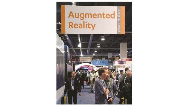 Attendees walk under an augmented reality sign during CES 2018 in Las Vegas, Nevada. A person familiar with Amazonu2019s thinking has said that itu2019s far more likely to choose  augmented reality if it makes a headset.