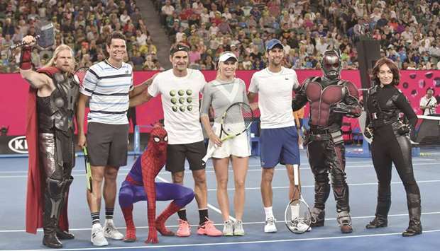 Canadau2019s Milos Raonic (second from left), Switzerlandu2019s Roger Federer (fourth from left), Denmarku2019s Caroline Wozniacki (centre), and Serbiau2019s Novak Djokovic (third from right) pose with Marvel superhero characters for a Kids Day event ahead of the Australian Open in Melbourne yesterday. (AFP)