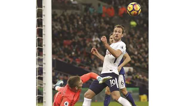 Tottenham Hotspuru2019s English striker Harry Kane (R) scores the teamu2019s third goal against Everton at Wembley Stadium in London yesterday.