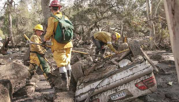 Rescue workers search a car for missing persons after a mudslide in Montecito, California.