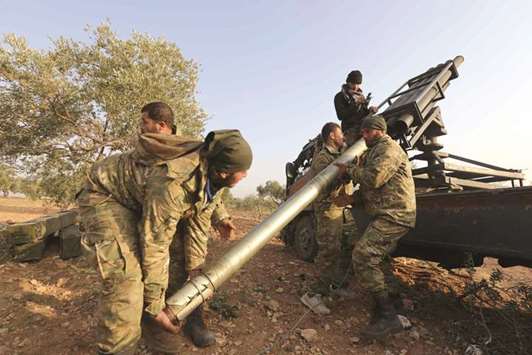Opposition fighters load a multiple rocket launcher before heading towards the frontline near the village of Al-Khuwayn during ongoing battles with government forces in Syriau2019s Idlib province, yesterday.