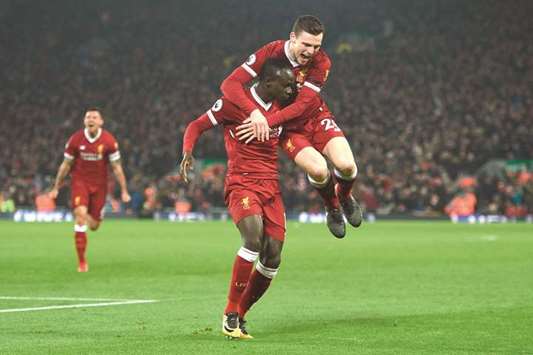 Liverpoolu2019s Senegalese midfielder Sadio Mane (L) celebrates scoring their third goal to extend their lead 3-1 with Liverpoolu2019s Scottish defender Andrew Robertson (R) during the English Premier League football match against Manchester City at Anfield yesterday.