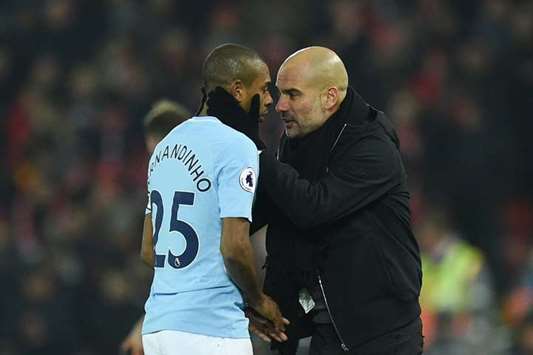 Manager Pep Guardiola (right) talks with Manchester Cityu2019s Fernandinho on the touchline during the EPL match against Liverpool yesterday. (AFP)
