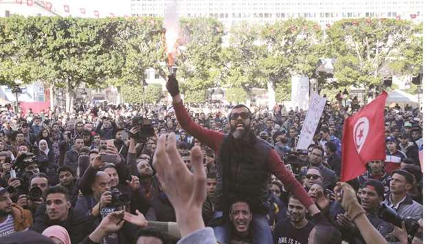 People shout slogans during demonstrations on the seventh anniversary of the toppling of president Zine El-Abidine Ben Ali, in Tunis, yesterday.
