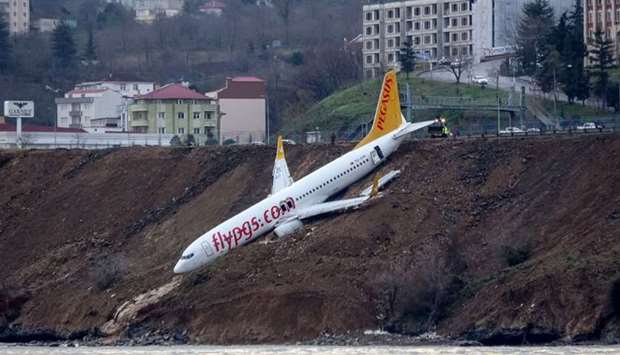 A Pegasus Airlines Boeing 737 passenger plane is seen struck in mud on an embankment, a day after skidding off the airstrip, after landing at Trabzon's airport on the Black Sea coast.