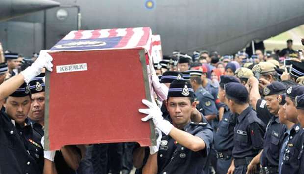 Royal Malaysian Police personnel carry a coffin of Zulkifli Mamat, an Inspector  of the  69th Commando Battalion, who was killed on Friday in the standoff between Malaysian security forces and armed followers of the Sultanate of Sulu, upon its arrival at the Air Force base airport in Subang, outside Kuala Lumpur. March 2, 2013 file picture.