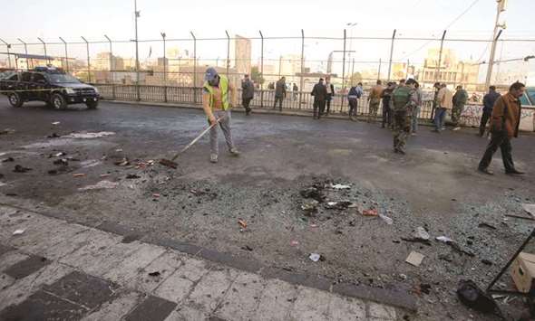 Iraqi security forces inspect the site of a bomb attack in Baghdad, yesterday.