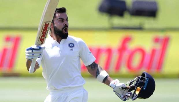 India's captain Virat Kohli raises his bat and helmet as he celebrates scoring a century (100 runs) during the third day of the second Test cricket match between South Africa and India at Supersport cricket ground on yesterday  in Centurion, South Africa.  AFP