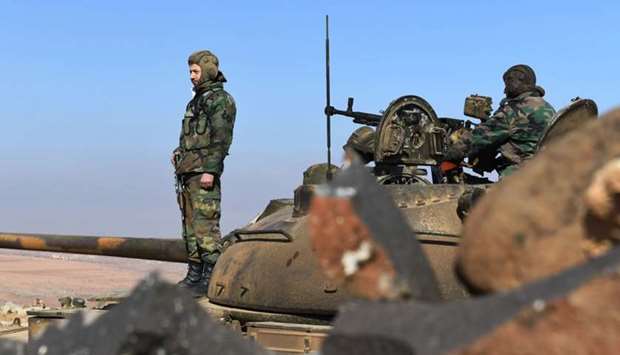 Members of the Syrian government forces stand on a tank in Jabal al-Hass in the southern part of Aleppo province as they advance towards the Abu Duhur military airport in the ongoing offensive against opposition fighters on Sunday.