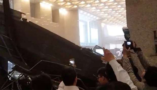 People photograph the damage seen inside the Indonesia Stock Exchange (IDX) building in Jakarta