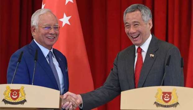 Malaysia's Prime Minister Najib Razak shakes hands with his Singaporean counterpart Lee Hsien Loong after a joint press conference at the 8th Singapore-Malaysia leaders retreat in Singapore on Tuesday.