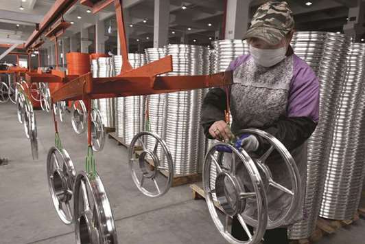 A woman works on a production line of shared bicycle wheels at a plant in Jinhua, Zhejiang province. Chinau2019s economy expanded 6.8% in 2017, much better than the  official target of around 6.5%, according to the poll of 11 financial experts.