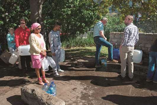 A May 15, 2017, file photo of people queuing up to collect drinking water from taps that are fed by a spring in Newlands, Cape Town.