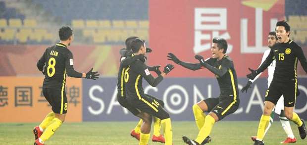 Malaysian players celebrate their victory over Saudi Arabia in their final Group C match in the AFC U23 Championship yesterday.