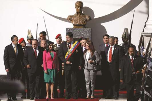 Venezuelau2019s President Nicolas Maduro (centre) stands in front of a bust of South American independence leader Simon Bolivar as he arrives for a special session of the National Constituent Assembly to present his annual state of the nation at the Palacio Federal Legislativo in Caracas, Venezuela.
