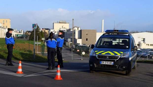 French gendarmes stand guard close to the entrance of the Celia dairy company's infant milk factory, a subsidiary of French dairy giant Lactalis, in Craon, western France.