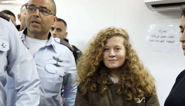 Palestinian teen Ahed Tamimi enters a military courtroom escorted by Israeli security personnel at Ofer Prison