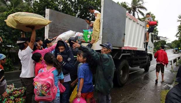 Residents with their belongings board a truck as they prepare to depart to the evacuation center after Mayon volcano spews ashes, in Ligao city, Albay province