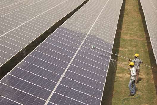 Workers clean photovoltaic panels inside a solar power plant in Gujarat. Indiau2019s installed renewable power capacity is currently about 60 gigawats, and the country plans to complete the bidding process by the end of 2019-20 to add a further 115GW of installed renewable energy capacity by 2022.