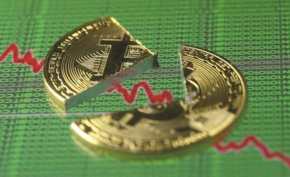 Broken representation of the Bitcoin, placed on a monitor that displays stock graph and binary codes, are seen in this illustration, Bitcoin skidded a further 12% yesterday, marking an almost halving in value from its peak price, with investors spooked by fears regulators could clamp down on the volatile cryptocurrency that skyrocketed last year.