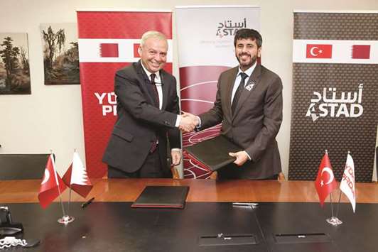 Astad CEO engineer Ali al-Khalifa and Yu00fcksel Proje chairman Celal Akin shake hands after signing the agreement in Ankara.