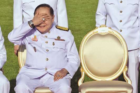In this photograph taken on December 4, 2017, Thailandu2019s junta number two Prawit Wongsuwan covers his eyes, displaying a watch he is wearing, during a photo call with other members of a new cabinet in Bangkok.