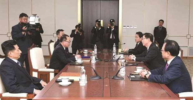South Korean delegation members talking with North Korean delegation members during their working-level talks in the Demilitarised zone dividing the two Koreas.