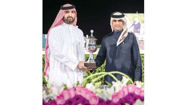Jassim bin Ali al-Attiyah (left) receives the owneru2019s trophy from Al Shaqabu2019s Nasser Ali al-Kuwari after Rassan won the Al Shaqab Cup at the Qatar Racing and Equestrian Club yesterday. PICTURE: Juhaim