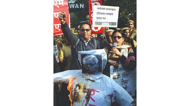 Activists shout slogans during a protest as they burn an effigy of Haryana Chief Minister Manohar Lal Khattar in New Delhi yesterday against the gang-rape of two schoolgirls in Haryana.