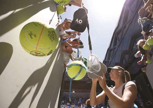 Maria Sharapova of Russia signs autographs after winning against Tatjana Maria of Germany on Tuesday. (Reuters)