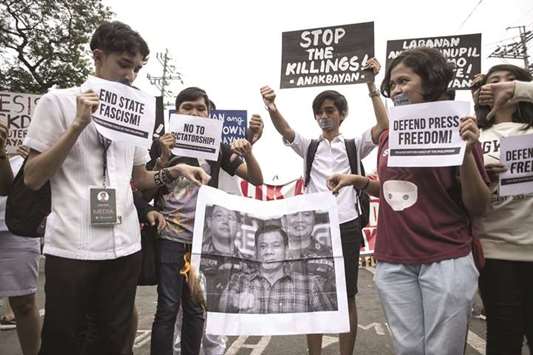 College students participate in a protest to defend press freedom in Manila yesterday.