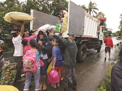 Residents with their belongings board a truck as they prepare to depart to the evacuation centre after Mayon volcano spews ashes, in Ligao city, Albay province, yesterday.