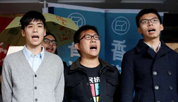 Pro-democracy activists (L-R) Lester Shum, Raphael Wong and Joshua Wong chant slogans outside High Court before receiving their sentences in Hong Kong.  Reuters