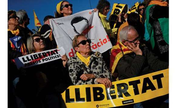People hold placards reading u2018Free political prisonersu2019 outside Catalanu2019s parliament during its inaugural session in Barcelona yesterday.