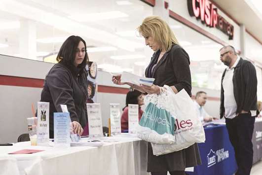 A job seeker (right), speaks to a representative at a job fair at Belknap Mall in Belmont, New Hampshire (file). The US Labour Department said initial claims for state unemployment benefits dropped 41,000 to a seasonally adjusted 220,000 for the week ended January 13, the lowest level since February 1973.
