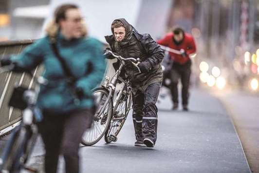 Cyclists walk through fierce winds yesterday in Rotterdam during the second western storm of the year.