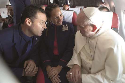 Pope Francis with flight crew members Paula Podest and Carlos Ciufffardi during the flight between Santiago and the northern city of Iquique, Chile.