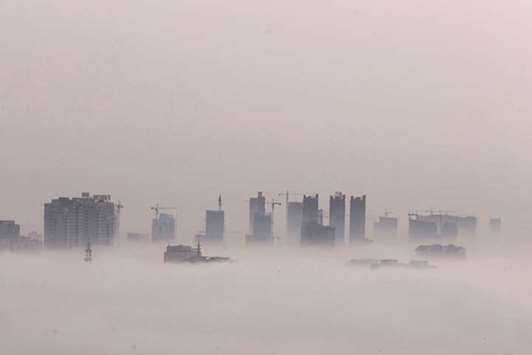 Cranes on skyscrapers are seen amid heavy fog yesterday in Huaian, Jiangsu province, China.