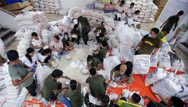 Soldiers and government employees prepare relief goods to be distributed to the evacuees affected by the minor eruption of Mayon Volcano in Albay province, south of Manila, on Thursday.